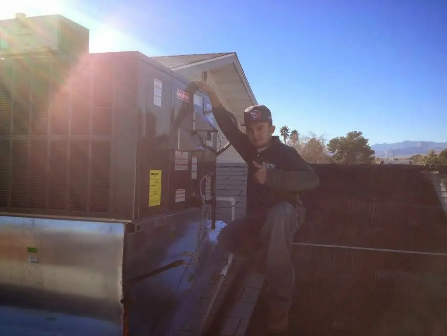 HVAC technician performing Air Duct Cleaning on a rooftop unit in Oregon City